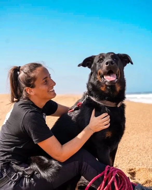 Inès sur la plage avec son beauceron, moment de complicité